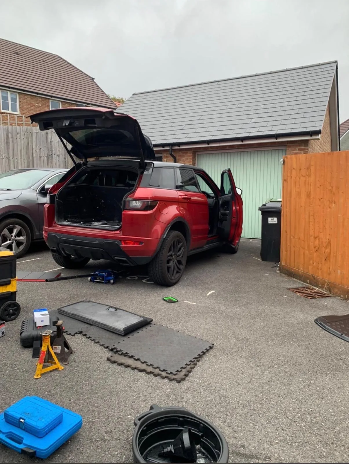 Mobile mechanic servicing a customer's Range Rover Evoque on their home driveway in Greater London